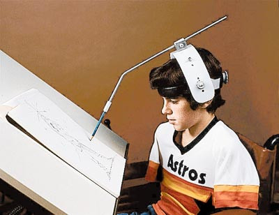 boy wearing adjustable head pointer drawing a picture