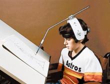 boy wearing adjustable head pointer drawing a picture